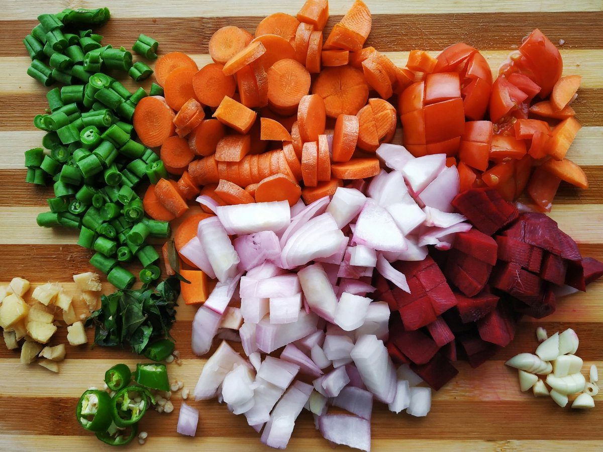 Légumes coupés en petits dés sur une planche en bois