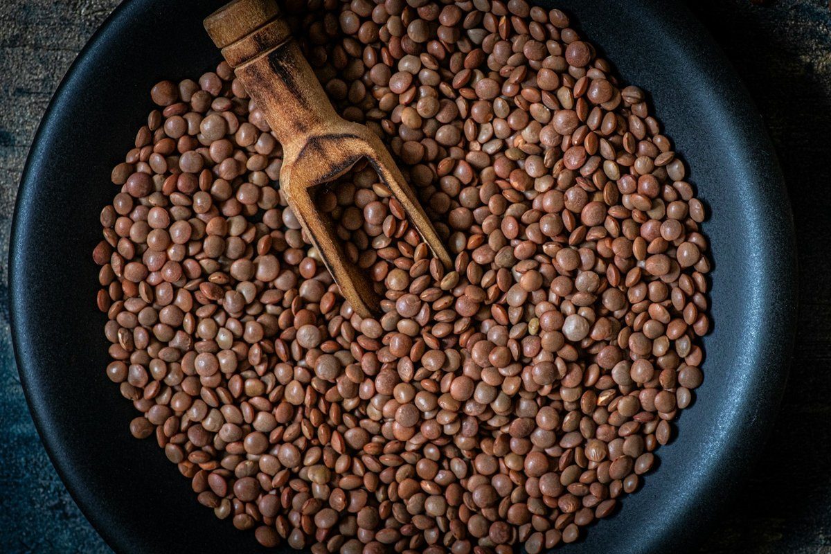 Lentilles blondes dans une poêle avec une pelle en bois