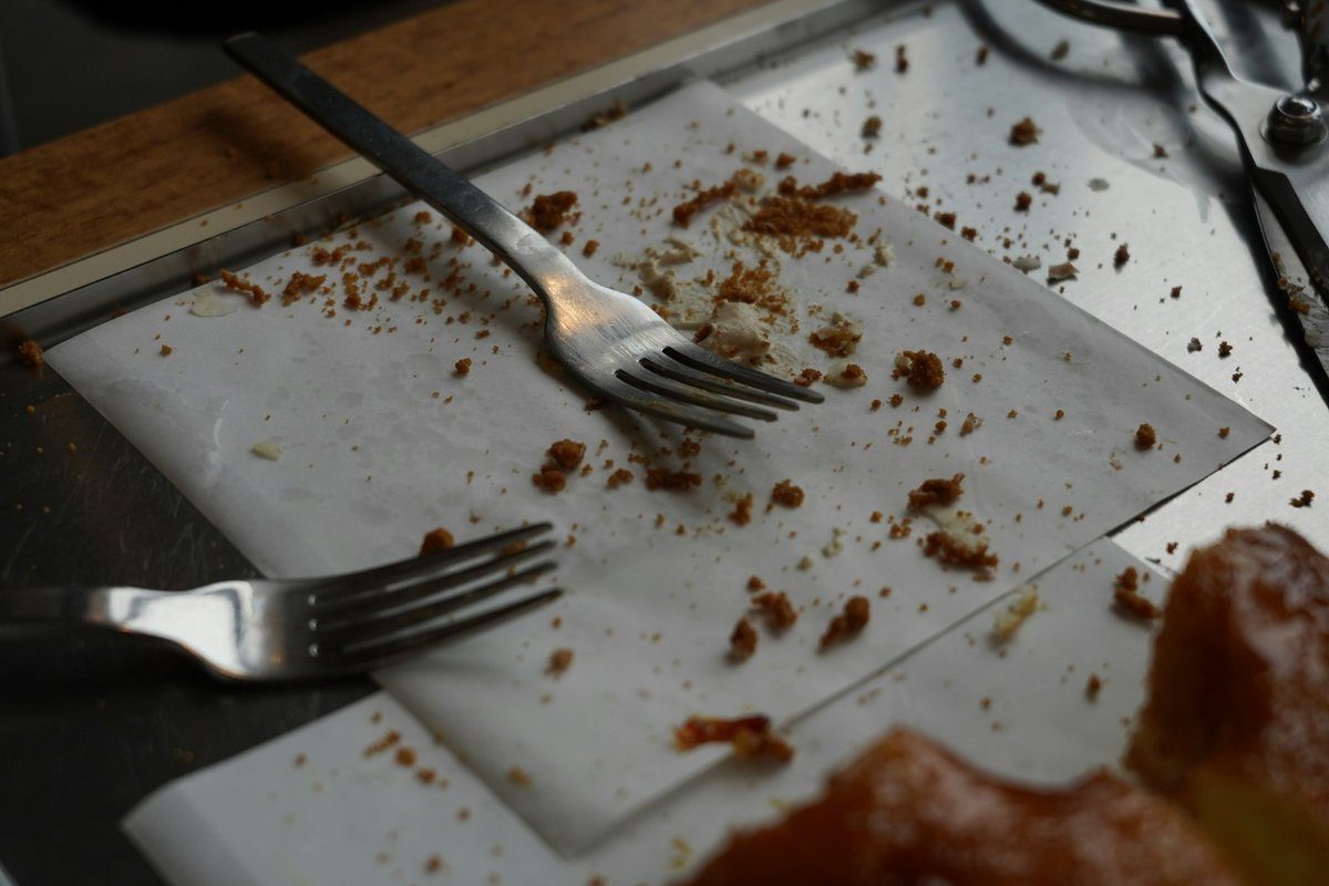 Miettes et deux fourchettes sur une assiette après le dessert